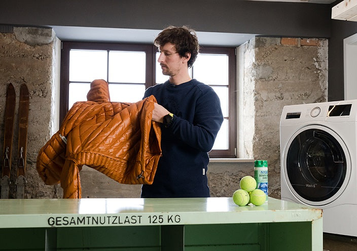 Mann checkt Daunenjacke